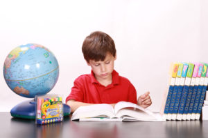 boy doing school work at home to show distance learning